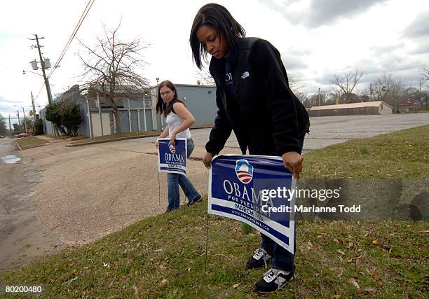 Meredith Lilly of Birmingham, Alabama, and Jenn Prisser, of Colorado put out Obama signs near a voting precinct during the Democratic primary March...