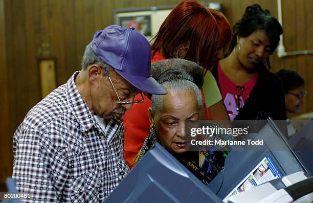 Charles Holloway is helped by a friend at a voting machine in a precinct during the Democratic primary March 11, 2008 in Meridian, Mississippi....