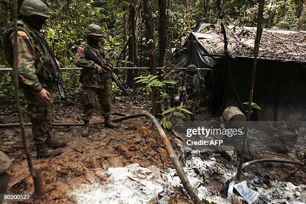 Ecuadorean soldiers inspect the area around an illegal cocaine laboratory found hidden in the jungle around Los Cofanes, near the border with...