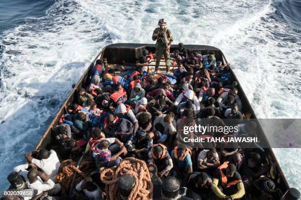 Libyan coast guardsman stands on a boat during the rescue of 147 illegal immigrants attempting to reach Europe off the coastal town of Zawiyah, 45...