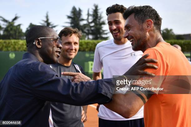 Milan's former player Paolo Maldini speaks with AC Milan's former player Clarence Seedor after the men's doubles tennis match, with his partner...