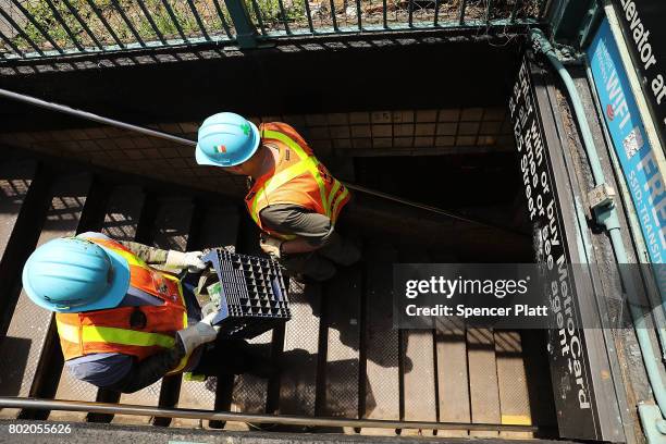 Metropolitan Transportation Authority workers enter a Harlem subway station where a morning train derailment occurred on June 27, 2017 in New York...