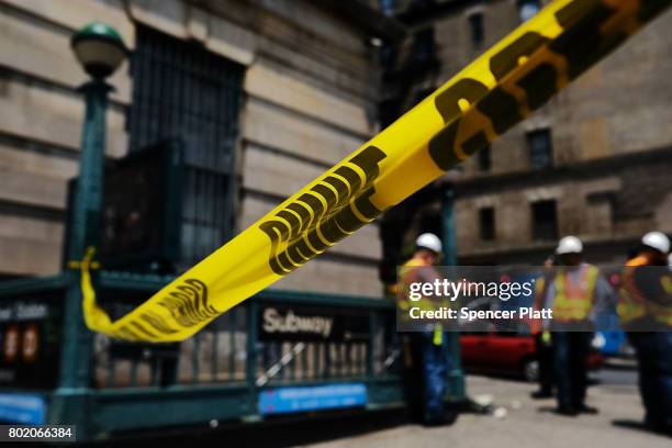 Crime scene tape is placed outside of a Metropolitan Transportation Authority Harlem subway station where a morning train derailment occurred on June...