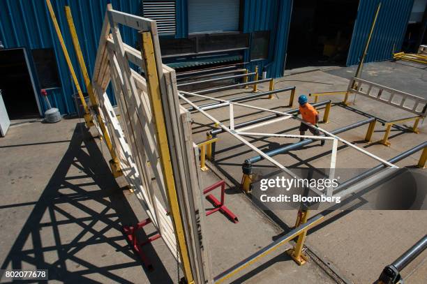 Workers stack roof trusses for distribution in the yard of the 84 Lumber Co. California Truss Plant in Coal Center, Pennsylvania, U.S., on Friday,...