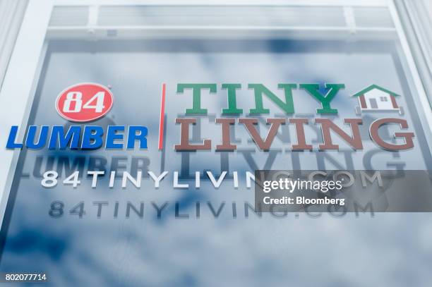 The sky is reflected on the glass door of a model Tiny House outside the 84 Lumber Co. Headquarters in Eighty Four, Pennsylvania, U.S., on Thursday,...