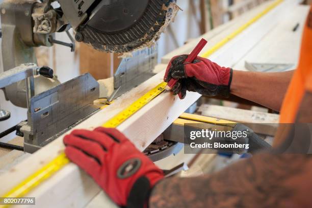 Worker measures wood while making wall panels at the 84 Lumber Co. California Truss Plant in Coal Center, Pennsylvania, U.S., on Friday, June 9,...