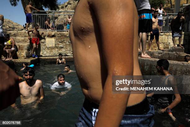 Palestinians swim in a natural spring in Ein Fawwar, in the Wadi Qelt area, near the West Bank city of Jericho, on June 27 on the last day of Eid...