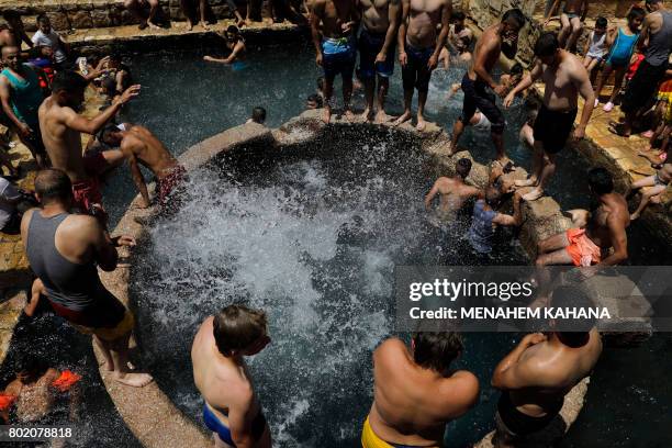 Palestinians swim in a natural spring in Ein Fawwar, in the Wadi Qelt area, near the West Bank city of Jericho, on June 27 on the last day of Eid...