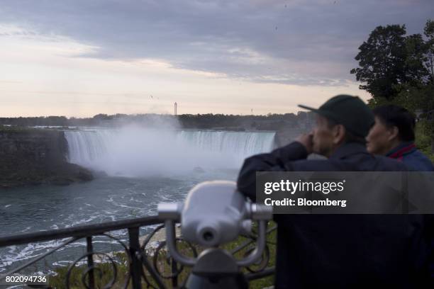 Tourists stand in front of the Horseshoe Falls in Niagara Falls, Ontario, Canada, on Wednesday, June 21, 2017. The 150th anniversary of Canada,...