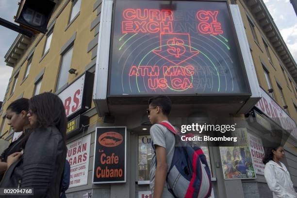 Pedestrians walk past a currency exchange in Niagara Falls, Ontario, Canada, on Wednesday, June 21, 2017. The 150th anniversary of Canada, promoted...