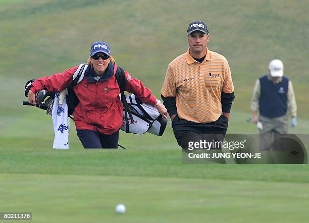 Chris DiMarco of the US walks with his caddy and wife Amy DiMarco during the afternoon Pro-Am event at the Pinx Golf Club in Jeju Island on March 12,...