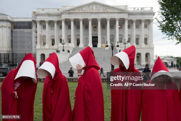 Supporters of Planned Parenthood dressed as characters from "The Handmaid's Tale," hold a rally as they protest the US Senate Republicans' healthcare...