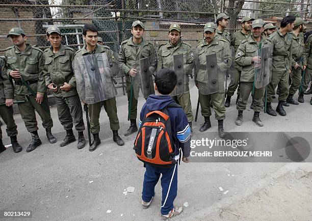 An Iranian boy chats with riot policemen following an anti-Danish protest in front of the embassy of Denmark in Tehran on March 12, 2008. Muslim...