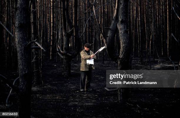 Ukrainian technician checks a spot with a Geiger counter in the forest which was burnt in 1992, seen here on June 1, 1998 in Chernobyl, Ukraine. It...