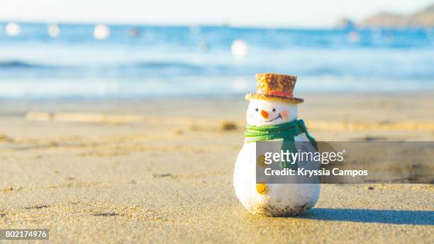snowman taking a sunbath on tropical beach - sand sculpture stockfoto's en -beelden