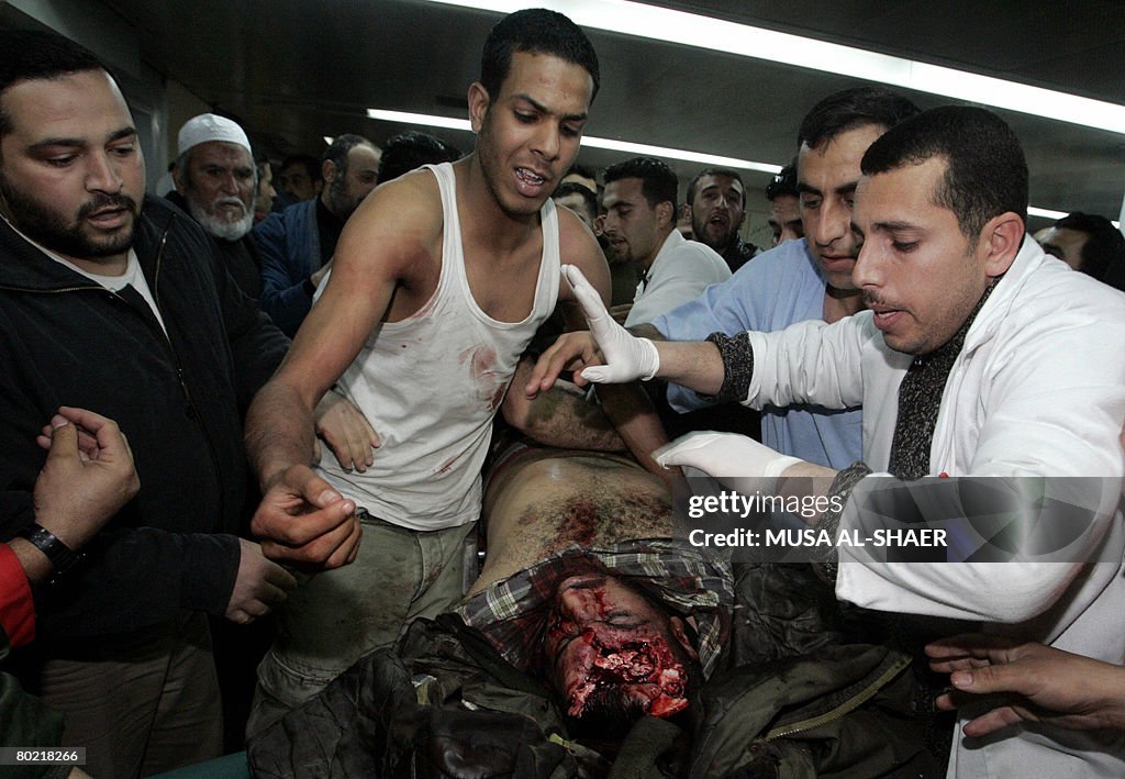 Palestinian mourners gather around the b