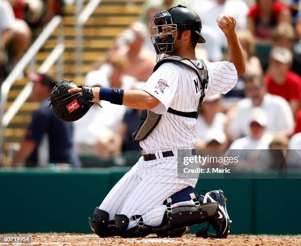 Catcher Joe Mauer of the Minnesota Twins warms up the pitcher against the Boston Red Sox during the Grapefruit League Spring Training game on March...