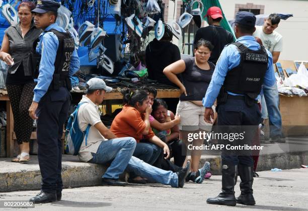 Relatives of a bus driver cry after he was killed by gang members for refusing to pay them a "war tax", over Soberania bridge which connects the...