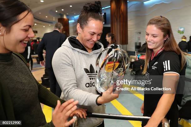 Michaela Blyde shows Portia Woodman her trophy for Impact Player of the Season with the New Zealand Black Ferns as they arrive at Auckland...