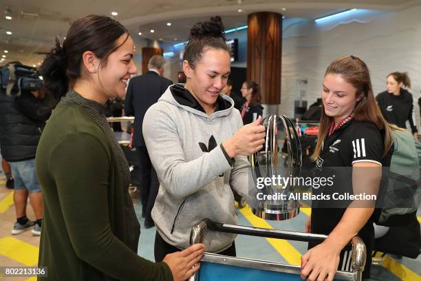 Michaela Blyde shows Portia Woodman her trophy for Impact Player of the Season with the New Zealand Black Ferns as they arrive at Auckland...