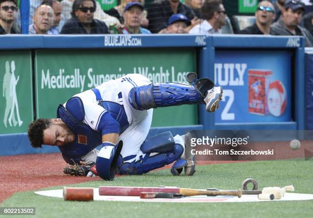 Russell Martin of the Toronto Blue Jays slides but cannot get to a pop up that bounces off the backstop screen in the third inning during MLB game...