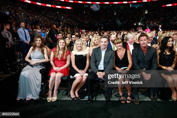 Denna Laing, far left, family guests and former NHL player Bobby Carpenter, second from right, sit in the front row during the 2017 NHL Awards &...