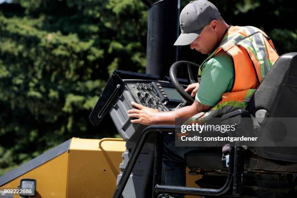 operator of asphalt paving equipment - asphalt paver stock pictures, royalty-free photos & images
