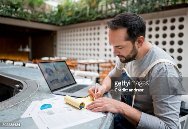business owner doing the books at a restaurant - business plan stock pictures, royalty-free photos & images