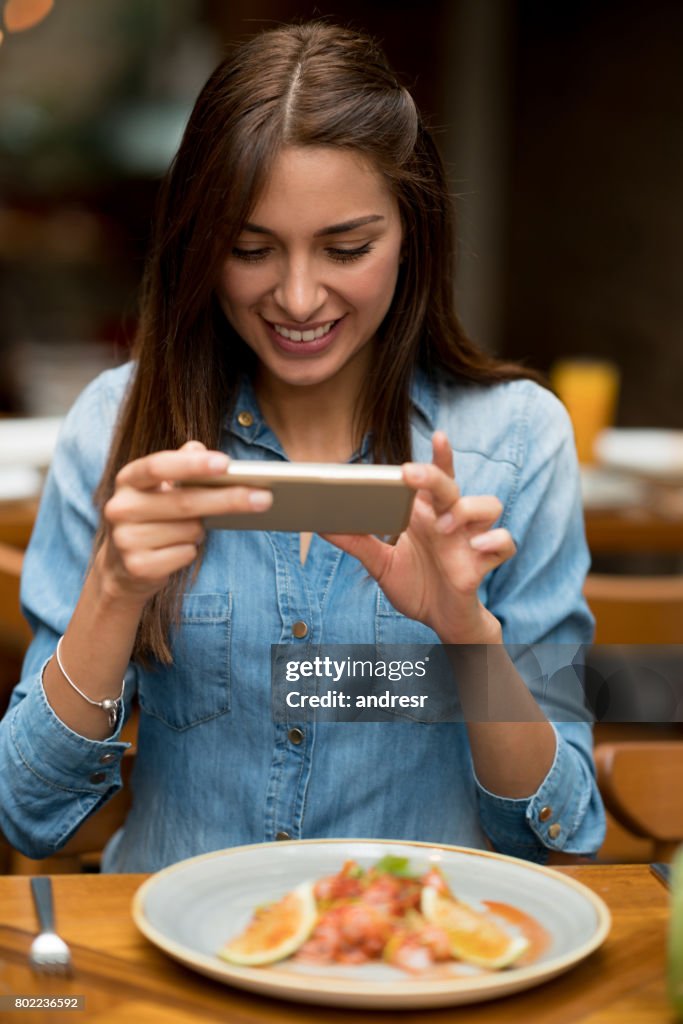 Frau, die ein Bild von ihr Essen in einem restaurant