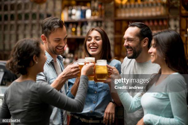 feliz grupo de amigos haciendo un brindis en un restaurante - amigos bar fotografías e imágenes de stock