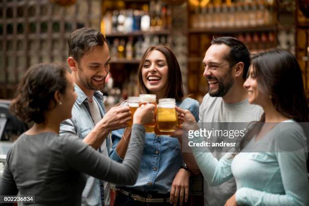 happy group of friends making a toast at a restaurant - cheer stock pictures, royalty-free photos & images