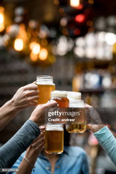 gruppe von freunden an der bar toasten - bier zapfhahn stock-fotos und bilder