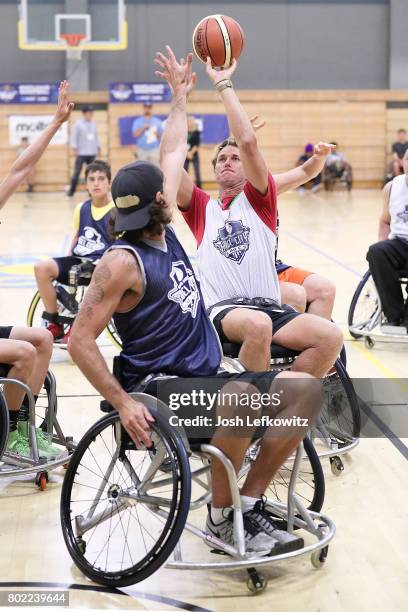 Olympic Swimmer Aaron Peirsol shoots the ball over former NFL player Chris Kluwe during the 3rd Annual Celebrity Wheelchair Basketball Game at the...