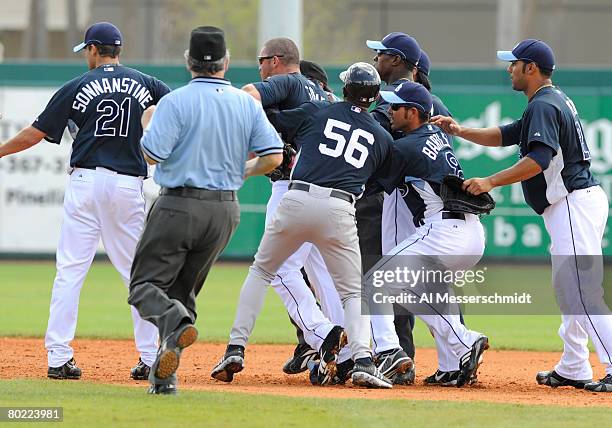 Outfielder Johnny Gomes of the Tampa Bay Rays is restrained as he charges into first baseman Shelley Duncan of the New York Yankees March 12, 2008 at...