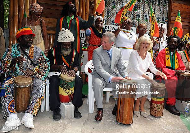 Prince Charles, Prince of Wales and Camilla, Duchess of Cornwall play the bongo drums as they join a group of musicians at Bob Marley's former home,...