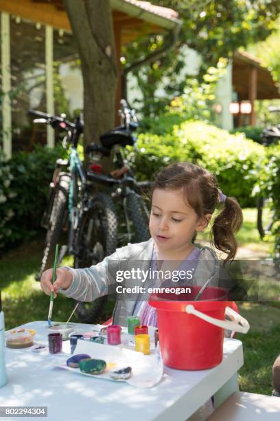 greenery,little girl paint rock in house yard - emreogan stock pictures, royalty-free photos & images