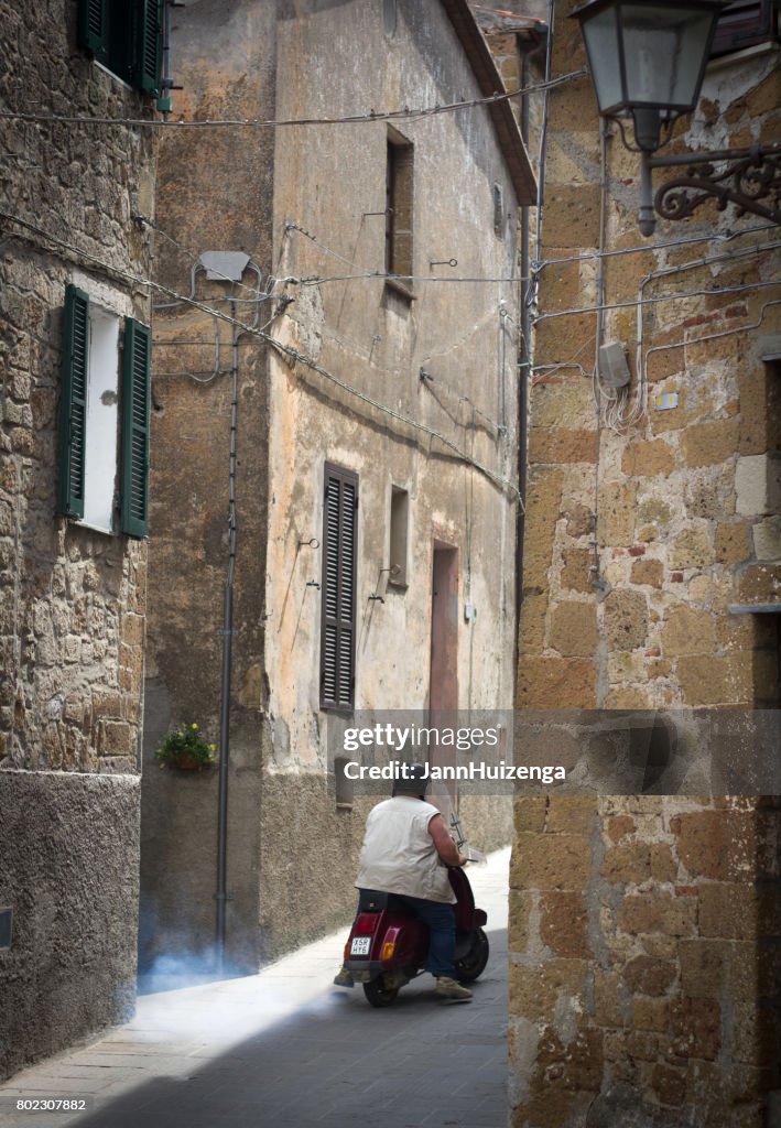Pitigliano, Tuscany, Italy: Large Man Riding Tiny Scooter
