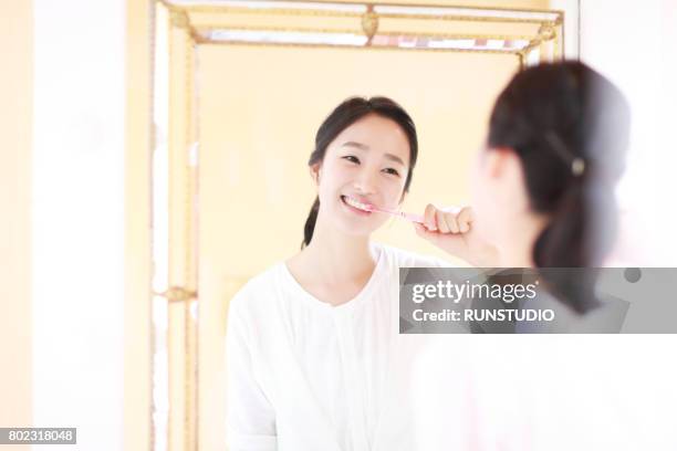woman brushing teeth - toothbrush ストックフォトと画像