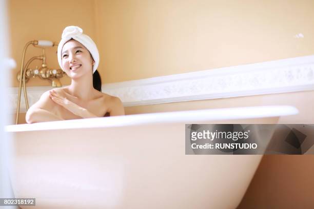 woman taking bath in modern bathroom - japanese women bath stock pictures, royalty-free photos & images
