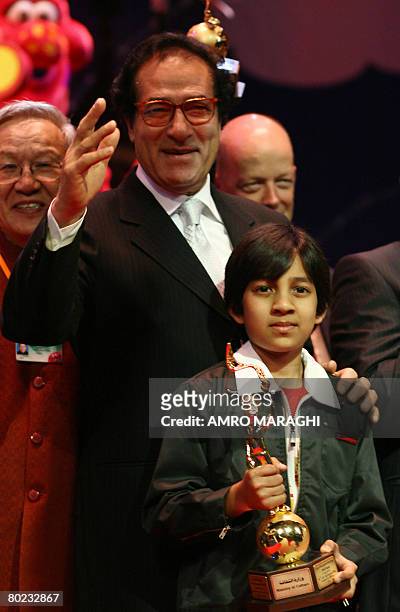 Egyptian Culture Minister Faruq Hosni gestures as Kishan Shrikanth, the youngest Indian film director, holds his award after his film "Care of...