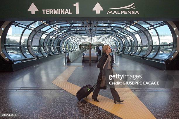 Passengers walk inside the Terminal 1 at Malpensa Airport, north of Milan, on March 13, 2008. The province of Milan intends to propose that SEA, the...