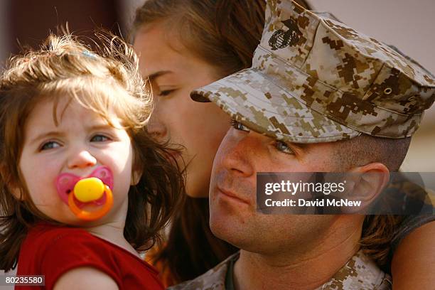 Cpl Matthew Alford holds his 20-month-old daughter Aubrey and wife Tara-Sky Alford before he and other Marines and Sailors of the 1st Air Naval...