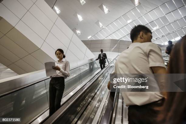 Attendees travel on escalators at the World Economic Forum Annual Meeting of the New Champions in Dalian, China, on Wednesday, June 28, 2017. The...