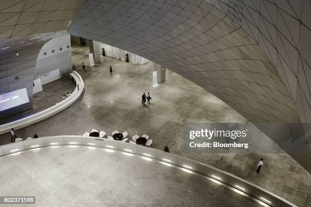 Attendees at the World Economic Forum Annual Meeting of the New Champions walk through the Dalian International Conference Center in Dalian, China,...