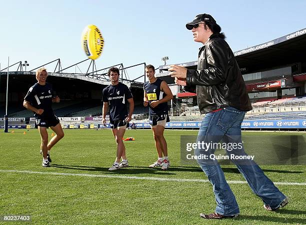 Gene Simmons of the band Kiss takes part in a handball drill as he visits a Carlton Blues AFL training session held at MC Labour Park March 14, 2008...