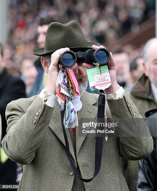 Racegoer looks through his binoculars during the David Nicholson Mares Hurdle race on day four of the Cheltenham festival at Cheltenham Racecourse on...