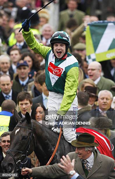 Jockey Sam Thomas riding the horse Denman celebrates after winning The Totesport Cheltenham Gold Cup steeple chase race followed by race favourite...