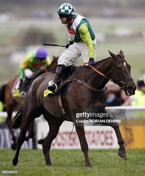 Jockey Sam Thomas riding the horse 'Denman' celebrates as he leads Kauto Star up the finish straight to win The Totesport Cheltenham Gold Cup steeple...