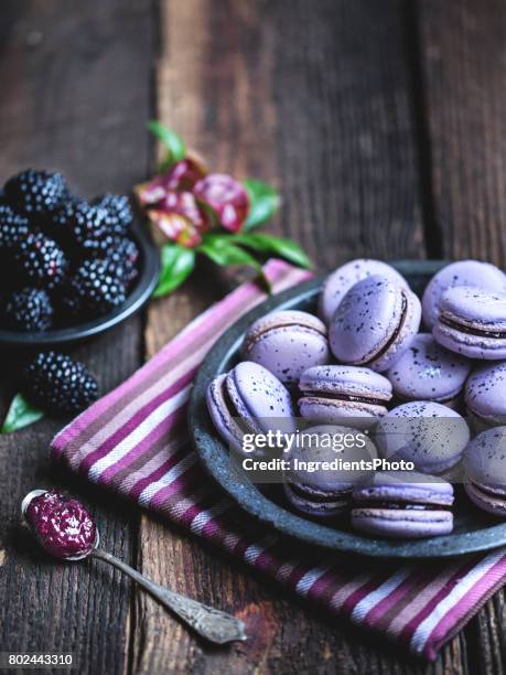 blackberry macarons op een rustieke houten tafel. - kokosmakroon stockfoto's en -beelden