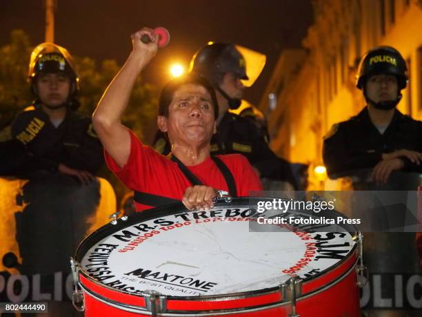 Demonstrator playing a bass drum in front of the police. Hundreds of workers, unionists, students, and unemployed groups marched through the streets...